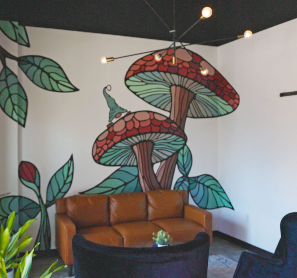 Completed mural at WELD Wine and Beer entryway mushrooms with gnome colorful art mural with couch and sitting area. Cary NC Full Circle Streaming and Digital Video production